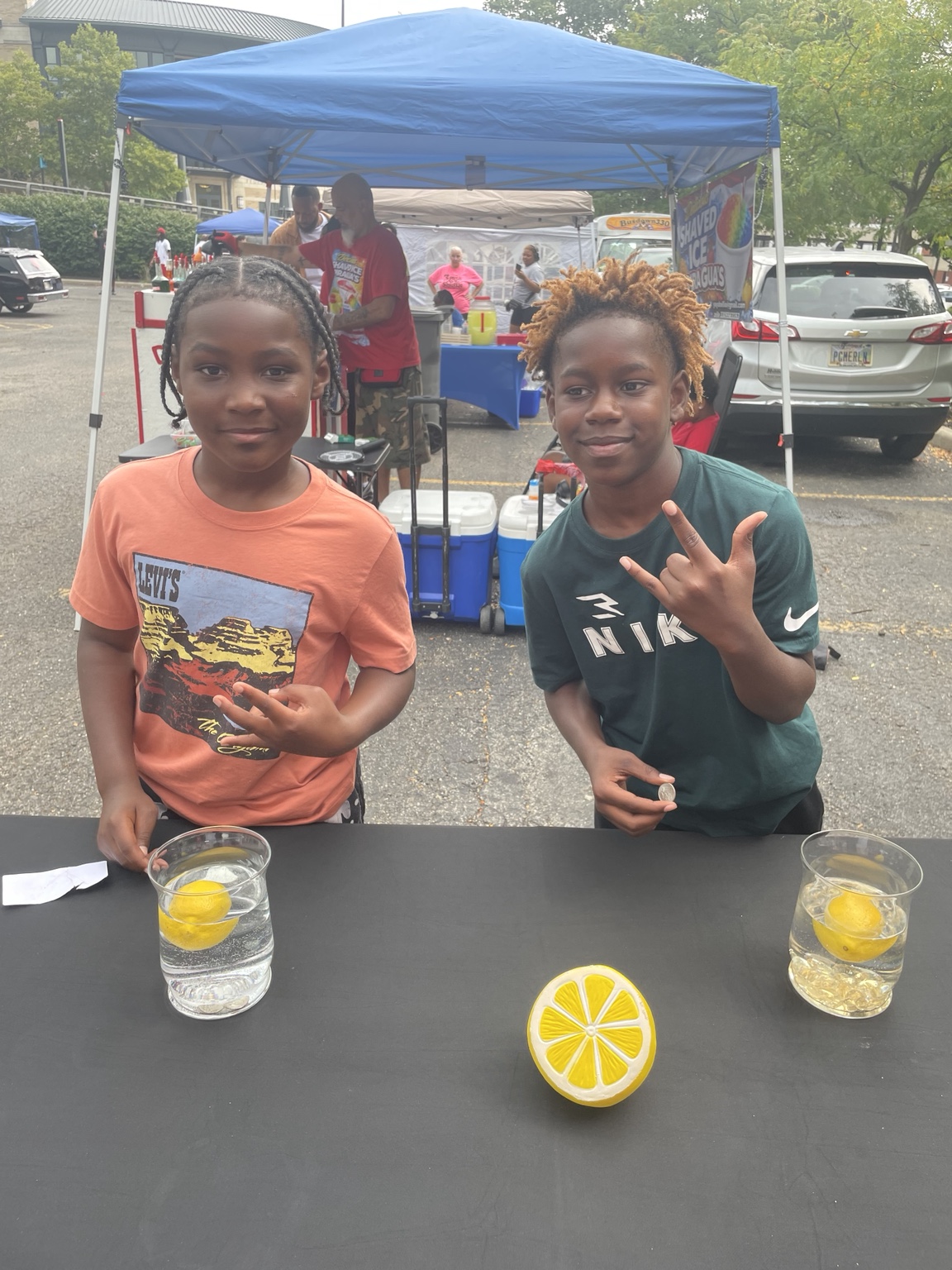 Two young people at the Quarter Balance Challenge with lemons and cups on the table